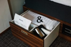 detaljer-på-hotellrum-låda-under-sängen-med-vattenkokare