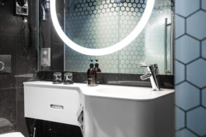 badrum-vitt-handfat-med-tvål-och-handkräm-rund-lysande-spegel
