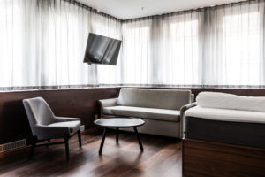 hotellrum-med-säng-soffa-litet-soffbord-och-tv-på-väggen
