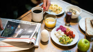 frukostbord med ägg, kaffe, juice, äggröra och dagstidning